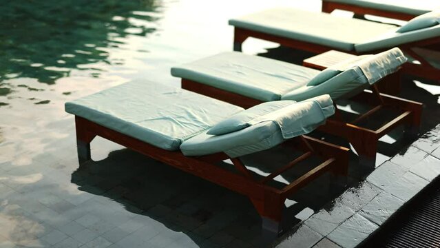 Empty beach lounger by the water at sunset