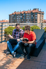 Fototapeta na wymiar Two colleagues working with laptop sitting on office rooftop
