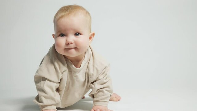 portrait of a child who has learned to crawl and is happy about it, on a light studio background