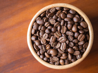Fototapeta premium brown arabica coffee bean roast level medium taste delicate lively bright seed caffeine espresso drink food cafe beverage Chiang Rai, Thailand coffee on wooden table background top view selected focus