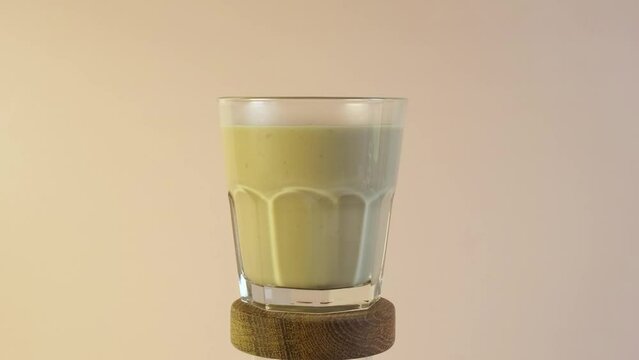 Karak tea or Masala chai in glass. Traditional Indian spicy drink. Video, 4K. Rotation.