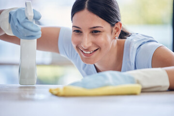 Happy woman, housekeeper and detergent for cleaning table, hygiene or bacteria and germ removal at...