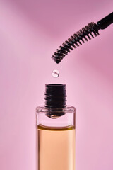 Cosmetic oil for the growth of eyebrows and eyelashes with a brush.