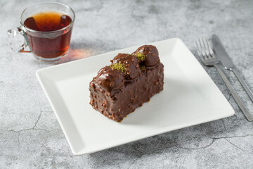 Cake with profiteroles with tea on stone table