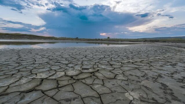 dry landscape of the river in the desert global warming and out of water idea with a cloudy sunset sky with 4K timelapse