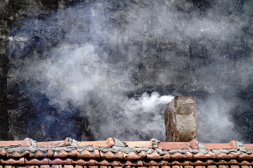 Smoking chimney in house with stove heating. Harmful emissions into atmosphere, poor air quality...