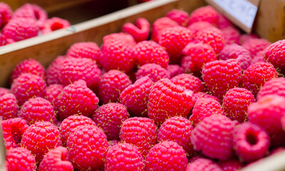 Reife frische Himbeeren in Nahaufnahme, die auf einem lokalen Markt angeboten werden.