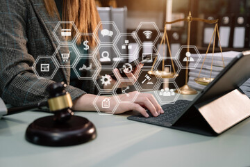 Justice and law concept. Female judge in a courtroom the gavel, working with digital tablet computer on wood table in sun light.