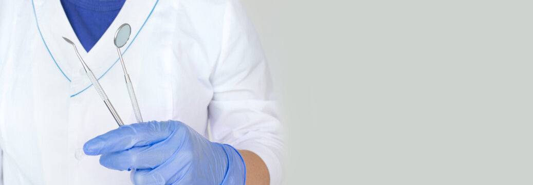 Different tools for dental care in docktor hand. Dental background. With copy space, close-up. Oral dental hygiene concept