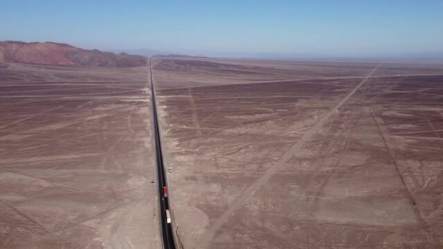 Aerial video of flat desert plateau that holds the famous Nazca Lines. Drone orbits above. Below is a highway and all around are long linear geoglyphs and many more symbols. Located in Nazca, Peru.