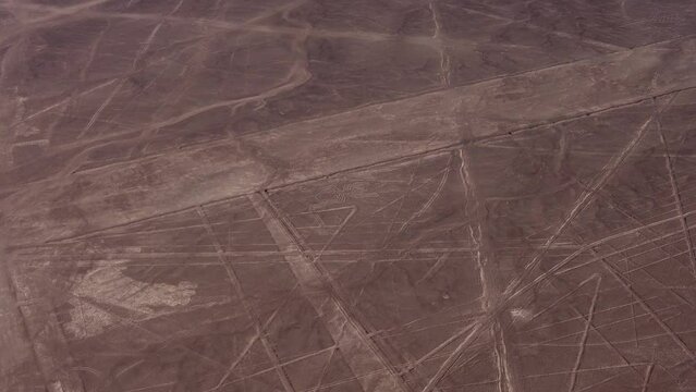 Aerial video of the famous Nazca Lines. Drone flies above many long linear geoglyphs and a depiction of a spider. Located in desert plateau of Nazca, Peru.