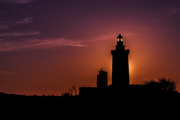 Lighthouse at sunset. Sunset behind the lighthouse of Cap Fr&eacute;hel, in the C&ocirc;tes d'Armor in France.