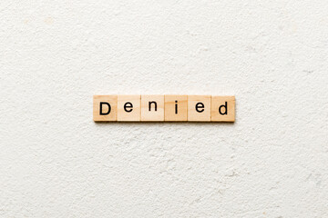 DENIED word written on wood block. DENIED text on cement table for your desing, concept