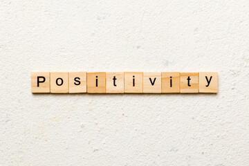 positivity word written on wood block. positivity text on cement table for your desing, concept