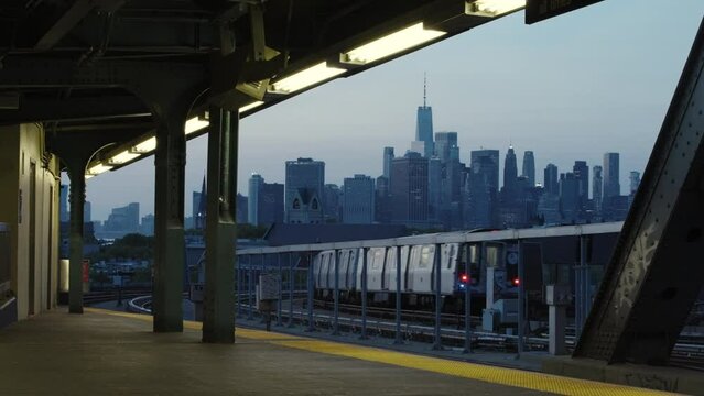 New York City Subway Train Leaving Station In The Evening With Manhattan Skyline