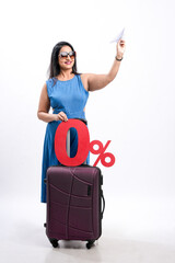 Indian woman traveler carrying suitcase and showing zero percent board on white background.