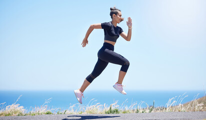 Runner woman, street and jump in nature with speed, fitness and energy for training, wellness and...