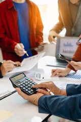 Businessman and team analyzing financial statement Finance task. with smart phone and laptop and ...