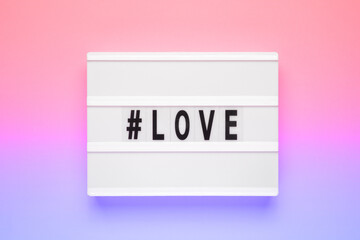 The word love on lightbox isolated pink background. Happy Valentines day concept. Romantic flat lay...