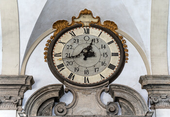 Fototapeta na wymiar The old clock above the entrance of the 