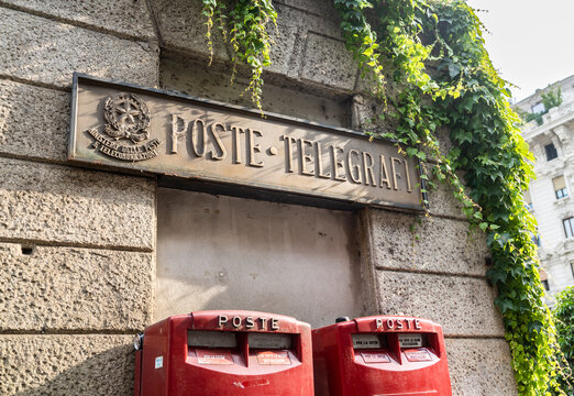 Old stone signboard meaning "Poste e Telegrafi" (post and telegraphs) and two modern red mail boxes in via dell'Orso, a street of Brera district, Milan city center, Italy