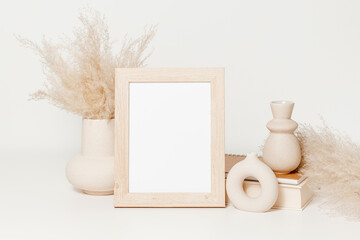 Wooden mockup photo frame with ceramic vases set, pampas grass, book and notebook. Picture frame...