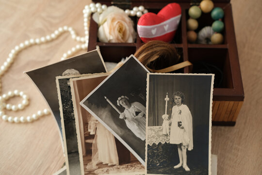 stack of old retro family sepia photos on table, vintage wooden box with dear heart memorabilia, concept of family tree, home archive, genealogy, memory of ancestors, childhood memories