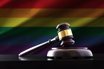 Judge mace on black table with LGBT flag background