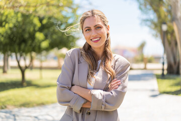 Young pretty blonde Uruguayan woman at outdoors keeping the arms crossed in frontal position