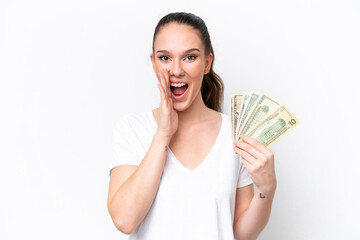 Young caucasian woman taking a lot of money isolated on white background shouting with mouth wide open