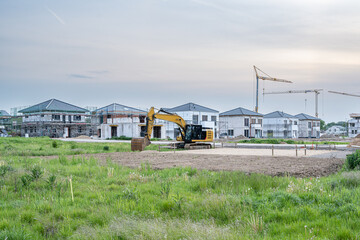 Neubau Häuser mit Bagger und Kran auf Baustelle