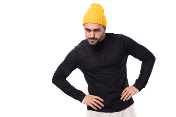 young brunette handsome caucasian male model with a beard dressed in a black jacket and a yellow cap