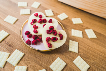 Hand-crafted heart-shaped white chocolate and chocolate bars with raspberries. High quality photo
