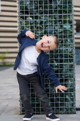 Cute child boy laughing with wow mouth open wide, surprised face. Young kid enjoying happy moment in funny shot in relaxing day. Concept of healthy lifestyle, happy expression, carefree, freedom.