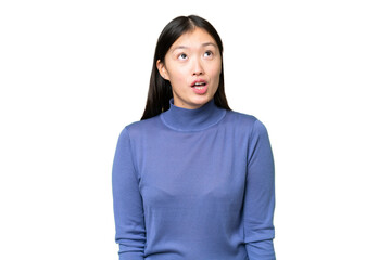 Young Asian woman over isolated chroma key background looking up and with surprised expression