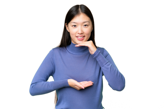 Young Asian woman over isolated chroma key background holding copyspace imaginary on the palm to insert an ad