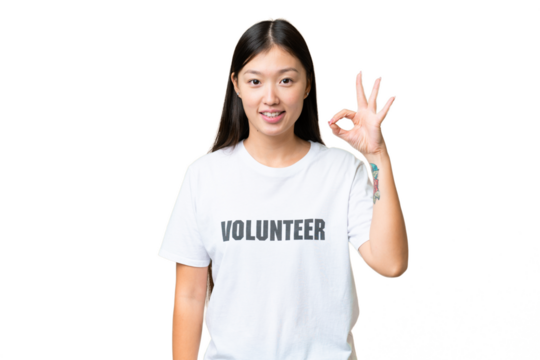 Young volunteer woman over isolated chroma key background showing ok sign with fingers
