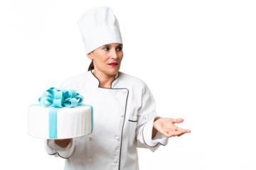 Middle-aged chef caucasian woman with a big cake over isolated background with surprise facial expression