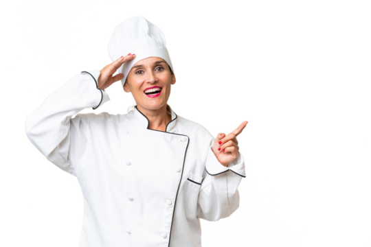 Middle-aged chef woman over isolated background surprised and pointing finger to the side