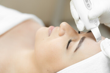 Softness and smoothness: as ultrasonic facial cleansing gently and effectively cleanses skin, improving texture. Beautician in beauty salon performs hardware procedure cleansing skin. Relax and rest