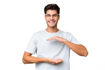 Young caucasian handsome man over isolated background holding copyspace imaginary on the palm to insert an ad