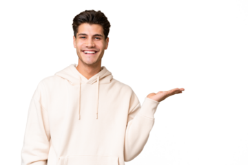 Young caucasian handsome man over isolated background holding copyspace imaginary on the palm to insert an ad