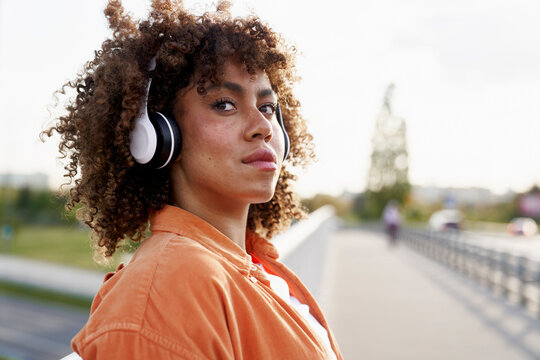 Young black woman wearing headphones and looking away