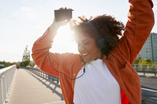 Close up of black woman wearing headphones and dancing on the bridge