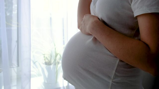 A pregnant woman drinks water. Selective focus.