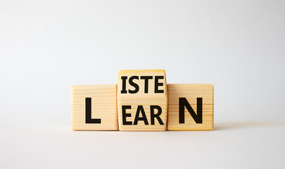 Listen and Learn symbol. Wooden cubes with words Learn and Listen. Beautiful white background. Listen and Learn and business concept. Copy space
