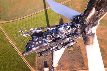 Close-up on wind turbine destroyed by fire after a lightning strike. Windmill over heated and set fire. Aerial view on top of the Striking Panorama of a Burned-Out Wind Turbine in a wind farm. Spain