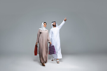 Beautiful arab middle-eastern couple with traditional emirate clothes in studio