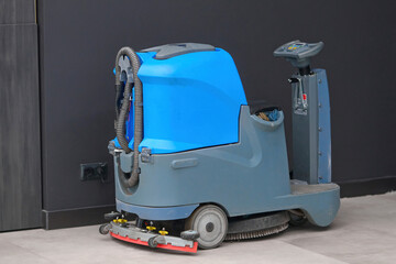 Floor cleaning machine electric floor scrubber stands at shopping mall at the electric point and...
