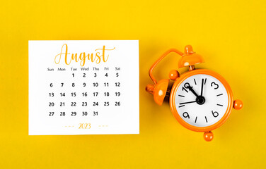 A August 2023 Monthly calendar for 2023 year with black colour alarm clock on yellow background.